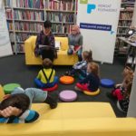 zdjęcie czytającej Pani i słuchających dzieci w bibliotece