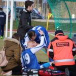 Kontuzjowany piłkarz na noszach w otoczeniu ratowników medycznych