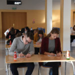 uczestnicy konkursu przy swoich ławkach skupieni na rozwiazaniu testu