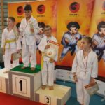 zawodnicy karate na podium z nagrodami