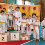 zawodnicy karate na podium z nagrodami