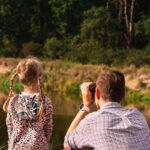 tata z córką oglądający przez lornetkę krajobraz przyrody